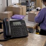 Business phone ringing beside shipping cartons