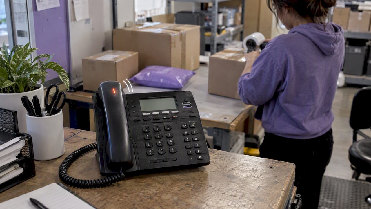 Business phone ringing beside shipping cartons